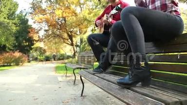 公园里男人弹吉他时美女唱歌